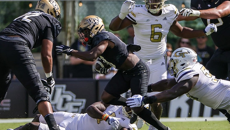 Sep 24, 2022; Orlando, Florida, USA; UCF Knights quarterback John Rhys Plumlee (10) is tackled by Georgia Tech Yellow Jackets defensive lineman D'Quan Douse (99) during the first quarter at FBC Mortgage Stadium. Mandatory Credit: Mike Watters-USA TODAY Sports