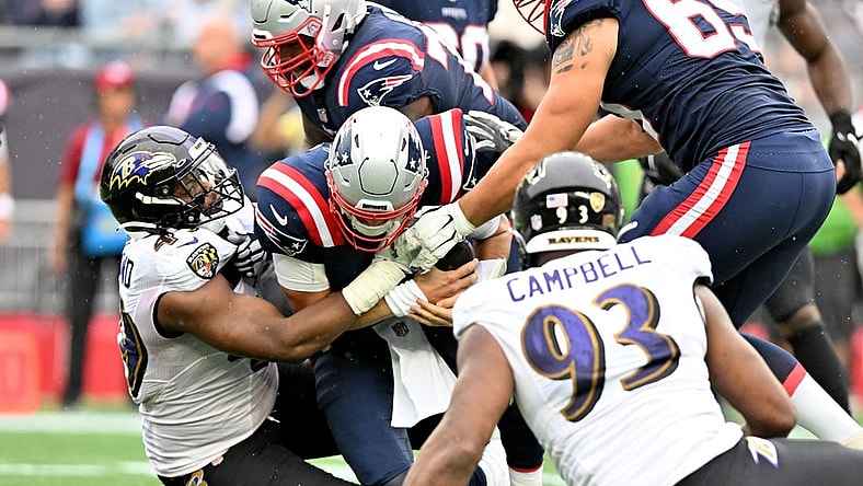 Sep 25, 2022; Foxborough, Massachusetts, USA; New England Patriots quarterback Mac Jones (10) is sacked by Baltimore Ravens linebacker Brandon Copeland (49) during the second half at Gillette Stadium. Mandatory Credit: Brian Fluharty-USA TODAY Sports