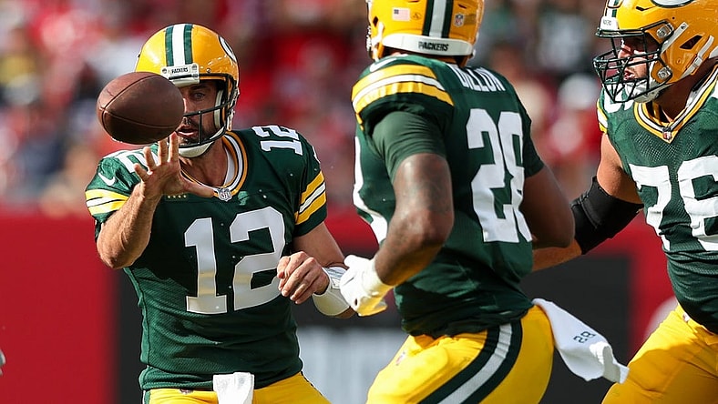 Sep 25, 2022; Tampa, Florida, USA; Green Bay Packers quarterback Aaron Rodgers (12) shuffles a pass to running back AJ Dillon (28) against the Tampa Bay Buccaneers in the second quarter at Raymond James Stadium. Mandatory Credit: Nathan Ray Seebeck-USA TODAY Sports