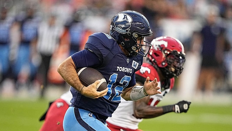 Aug 20, 2022; Toronto, Ontario, CAN; Toronto Argonauts quarterback Chad Kelly (12) and Calgary Stampeders defensive back Natrell Jamerson (16) at BMO Field. Mandatory Credit: John E. Sokolowski-USA TODAY Sports
