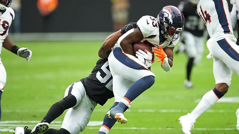 Oct 2, 2022; Paradise, Nevada, USA; Denver Broncos running back Javonte Williams (33) is tackled by Las Vegas Raiders linebacker Denzel Perryman (52) during a game at Allegiant Stadium. Mandatory Credit: Stephen R. Sylvanie-USA TODAY Sports
