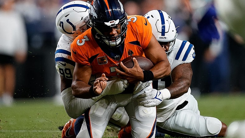 Oct 6, 2022; Denver, Colorado, USA; Denver Broncos quarterback Russell Wilson (3) is tackled by Indianapolis Colts defensive tackle DeForest Buckner (99) and defensive end Yannick Ngakoue (91) in the third quarter at Empower Field at Mile High. Mandatory Credit: Isaiah J. Downing-USA TODAY Sports