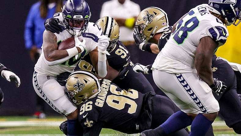 Oct 9, 2022; New Orleans, Louisiana, USA; Seattle Seahawks running back Rashaad Penny (20) is tackled by New Orleans Saints defensive end Carl Granderson (96) and defensive tackle Kentavius Street (91) during the first half at Caesars Superdome. Mandatory Credit: Stephen Lew-USA TODAY Sports