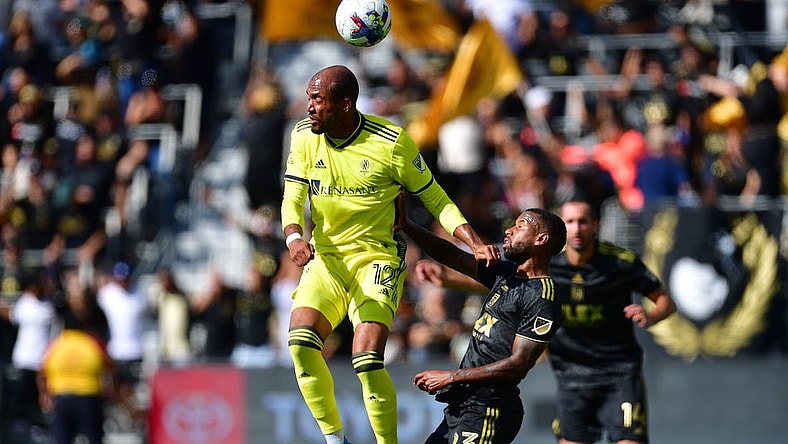 Oct 9, 2022; Los Angeles, California, USA; Nashville SC forward Teal Bunbury (12) plays for the ball against Los Angeles FC midfielder Kellyn Acosta (23) during the first half at Banc of California Stadium. Mandatory Credit: Gary A. Vasquez-USA TODAY Sports