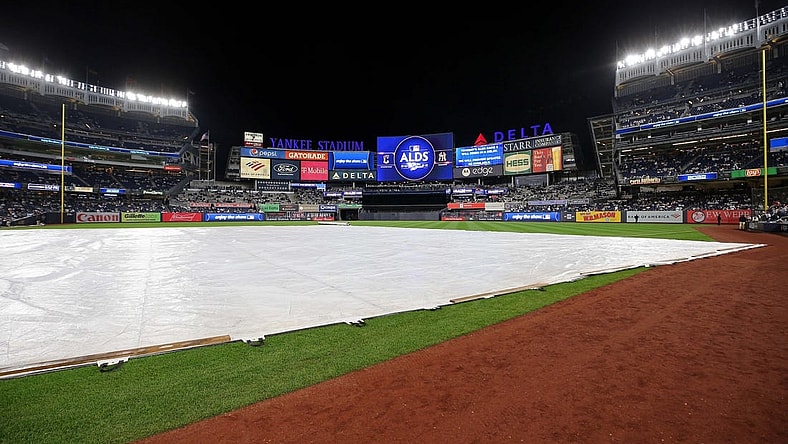 Oct 17, 2022; Bronx, New York, USA; A general view of the tarp on the field as the video board indicates a delay in game five of the ALDS for the 2022 MLB Playoffs between the New York Yankees and the Cleveland Guardians at Yankee Stadium. Mandatory Credit: Brad Penner-USA TODAY Sports