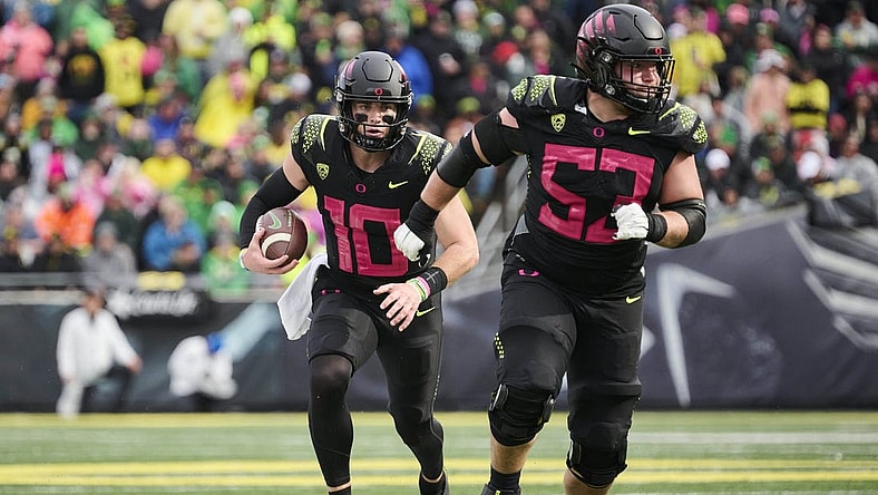 Oct 22, 2022; Eugene, Oregon, USA; Oregon Ducks quarterback Bo Nix (10) carries the football during the second half with help from offensive lineman Ryan Walk (53) against the UCLA Bruins at Autzen Stadium. The Ducks won the game 45-30. Mandatory Credit: Troy Wayrynen-USA TODAY Sports