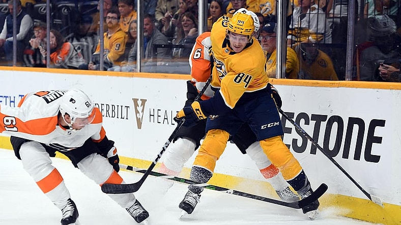 Oct 22, 2022; Nashville, Tennessee, USA; Nashville Predators left wing Tanner Jeannot (84) battles for the puck against Philadelphia Flyers defenseman Justin Braun (61) and defenseman Travis Sanheim (6) during the third period at Bridgestone Arena. Mandatory Credit: Christopher Hanewinckel-USA TODAY Sports