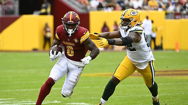 Oct 23, 2022; Landover, Maryland, USA; Washington Commanders running back Brian Robinson Jr. (8) runs past Green Bay Packers linebacker Rashan Gary (52) during the first half at FedExField. Mandatory Credit: Brad Mills-USA TODAY Sports