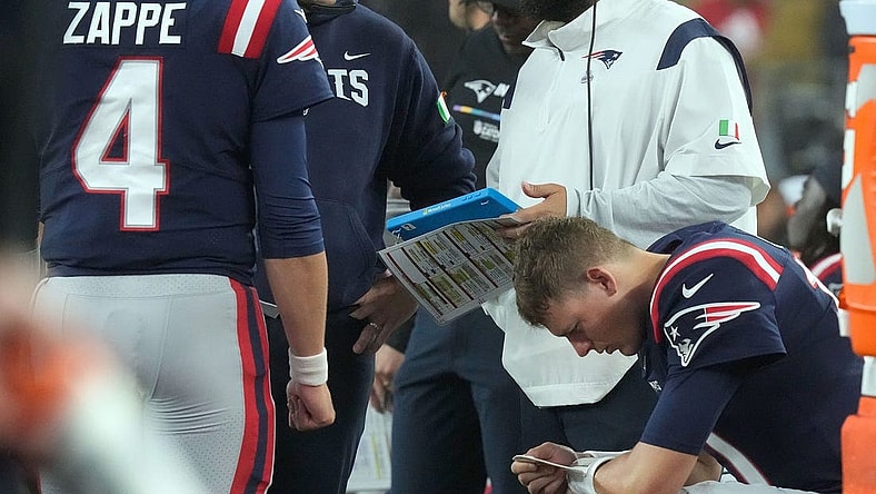Patriot coaches Joe Judge and Matt Patricia confer as they talk with QN Bailey Zappe as QB Mac Jones studies his play list on his wrist after Jones was replaced by Zappe during the 2nd quarter.

15 Pats Bears 102422 Bb