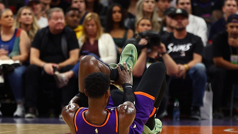 Oct 28, 2022; Phoenix, Arizona, USA; Phoenix Suns center Deandre Ayton (22) grabs his ankle after suffering an injury against the New Orleans Pelicans during the first half at Footprint Center. Mandatory Credit: Mark J. Rebilas-USA TODAY Sports