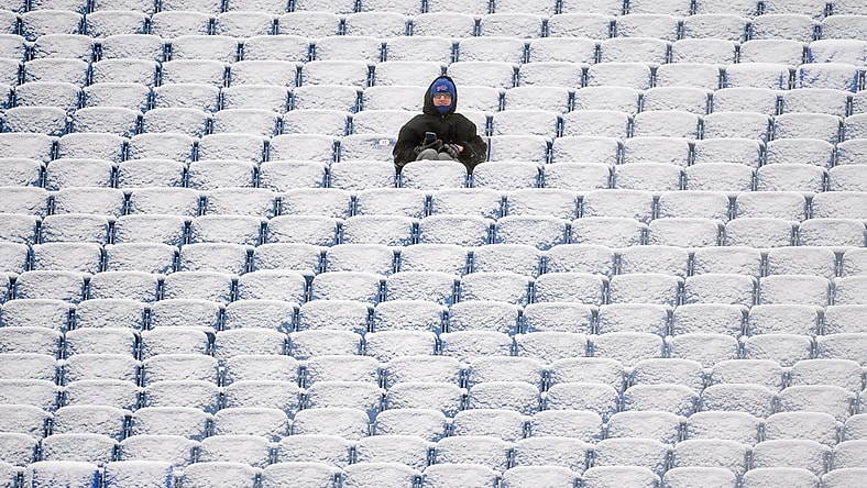 Jan 2, 2022; Orchard Park, New York, USA; A fan sits in the snow covered stands prior to the game between the Atlanta Falcons and the Buffalo Bills at Highmark Stadium. Mandatory Credit: Rich Barnes-USA TODAY Sports