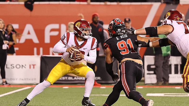 Oct 15, 2022; Salt Lake City, Utah, USA; USC Trojans quarterback Caleb Williams (13) scrambles away from the pressure of Utah Utes defensive end Gabe Reid (91) in the second quarter at Rice-Eccles Stadium. Mandatory Credit: Rob Gray-USA TODAY Sports