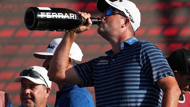 Oct 30, 2022; Miami, Florida, USA; Punch GC teammate Marc Leishman drinks champagne after his team finished second place in the team championship of the season finale of the LIV Golf series at Trump National Doral. Mandatory Credit: Jasen Vinlove-USA TODAY Sports