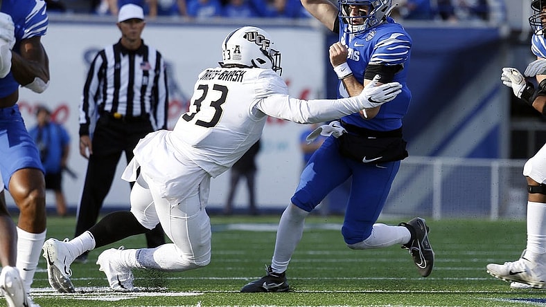 Nov 5, 2022; Memphis, Tennessee, USA; Memphis Tigers quarterback Seth Henigan (5) runs the ball as UCF Knights defensive end Tre'mon Morris-Brash (33) attempts to make the tackle during the first half at Liberty Bowl Memorial Stadium. Mandatory Credit: Petre Thomas-USA TODAY Sports