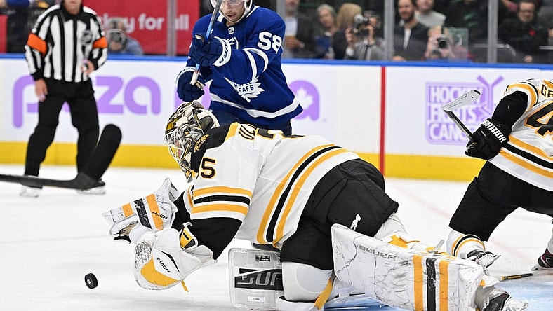 Nov 5, 2022; Toronto, Ontario, CAN; Boston Bruins goalie Linus Ullmark (35) dives to reach a loose puck ahead of Toronto Maple Leafs forward Michael Bunting (58) in the second period at Scotiabank Arena. Mandatory Credit: Dan Hamilton-USA TODAY Sports