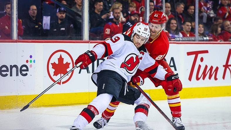 Nov 5, 2022; Calgary, Alberta, CAN; New Jersey Devils center Nico Hischier (13) and Calgary Flames center Kevin Rooney (21) battle for the puck during the first period at Scotiabank Saddledome. Mandatory Credit: Sergei Belski-USA TODAY Sports