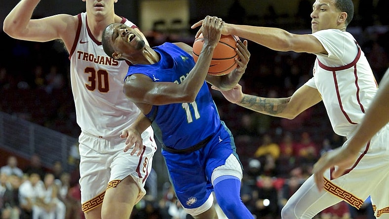 Nov 7, 2022; Los Angeles, California, USA; Florida Gulf Coast Eagles guard Isaiah Thompson (11) is defended by USC Trojans forward Harrison Hornery (30) and forward Kobe Johnson (0) as he drives to the basket in the second half at Galen Center. Mandatory Credit: Jayne Kamin-Oncea-USA TODAY Sports