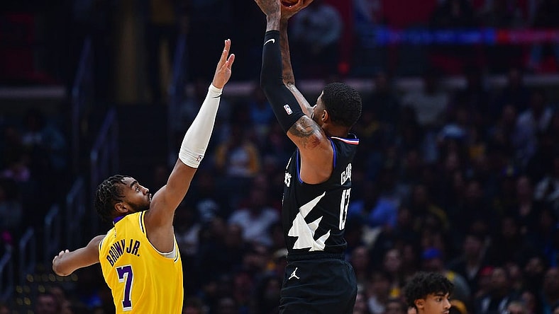 Nov 9, 2022; Los Angeles, California, USA; Los Angeles Clippers guard Paul George (13) shoots against Los Angeles Lakers forward Troy Brown Jr. (7) during the first half at Crypto.com Arena. Mandatory Credit: Gary A. Vasquez-USA TODAY Sports