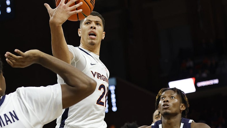 Nov 11, 2022; Charlottesville, Virginia, USA;  Virginia Cavaliers forward Kadin Shedrick (21) rebounds the ball in front of Monmouth Hawks forward Myles Foster (5) in the first halfat John Paul Jones Arena. Mandatory Credit: Geoff Burke-USA TODAY Sports
