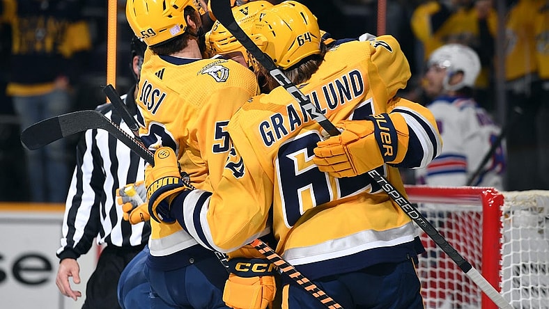 Nov 12, 2022; Nashville, Tennessee, USA; Nashville Predators center Juuso Parssinen (75) celebrates with defenseman Roman Josi (59) and center Mikael Granlund (64) after scoring his first career goal during the first period against the New York Rangers at Bridgestone Arena. Mandatory Credit: Christopher Hanewinckel-USA TODAY Sports