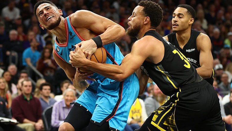 Nov 16, 2022; Phoenix, Arizona, USA; Phoenix Suns guard Devin Booker (1) battles for the ball against Golden State Warriors guard Stephen Curry (30) in the first half at Footprint Center. Mandatory Credit: Mark J. Rebilas-USA TODAY Sports