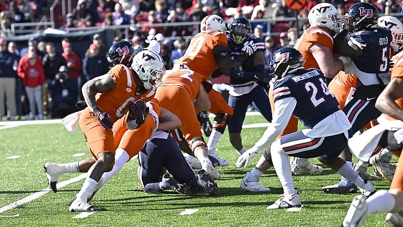 Nov 19, 2022; Lynchburg, Virginia, USA; Virginia Tech Hokies running back Jalen Holston (0 runs the ball  in the first half as Liberty Flames linebacker Aakil Washington (24) closes in at Williams Stadium. Mandatory Credit: Lee Luther Jr.-USA TODAY Sports