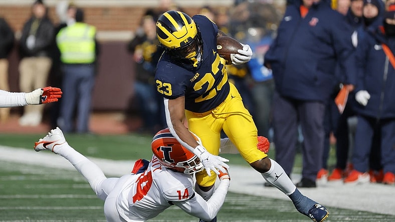 Nov 19, 2022; Ann Arbor, Michigan, USA; Michigan Wolverines running back C.J. Stokes (23) is tackled by Illinois Fighting Illini defensive back Xavier Scott (14) in the first half at Michigan Stadium. Mandatory Credit: Rick Osentoski-USA TODAY Sports