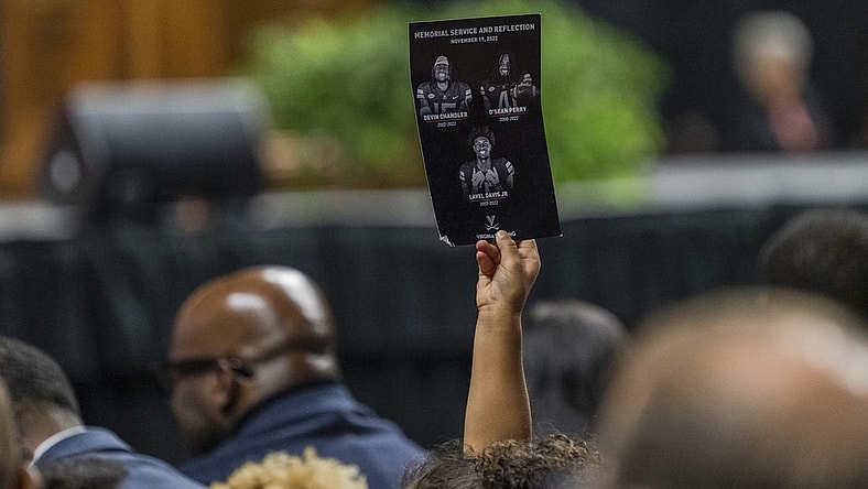 Nov 19, 2022; Charlottesville, Virginia, US; A flyer is held up during the memorial service for three slain University of Virginia football players Lavel Davis Jr., D Sean Perry and Devin Chandler at John Paul Jones Arena. Mandatory Credit: Erin Edgerton/Pool Photo-USA TODAY Sports