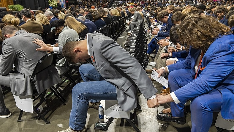 Nov 19, 2022; Charlottesville, Virginia, US; A general view as members of the Virginia Cavaliers football team pray during the memorial service for three slain University of Virginia football players Lavel Davis Jr., D Sean Perry and Devin Chandler at John Paul Jones Arena. Mandatory Credit: Erin Edgerton/Pool Photo-USA TODAY Sports