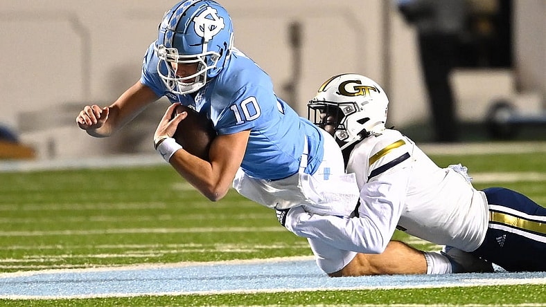 Nov 19, 2022; Chapel Hill, North Carolina, USA; North Carolina Tar Heels quarterback Drake Maye (10) is tackled by Georgia Tech Yellow Jackets linebacker Charlie Thomas (1) in the first quarter at Kenan Memorial Stadium. Mandatory Credit: Bob Donnan-USA TODAY Sports