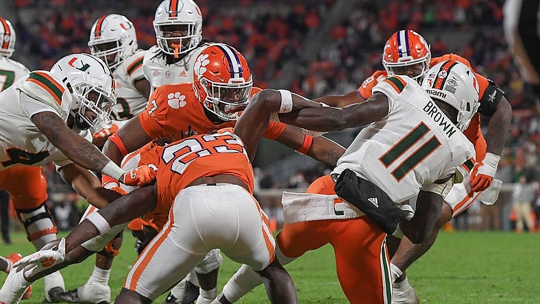 Nov 19, 2022; Clemson, South Carolina, USA; Clemson Tigers defensive end Justin Mascoll (7) pushes over Miami Hurricanes quarterback Jacurri Brown (11) for a safety during the third quarter at Memorial Stadium. Mandatory Credit: Ken Ruinard-USA TODAY Sports