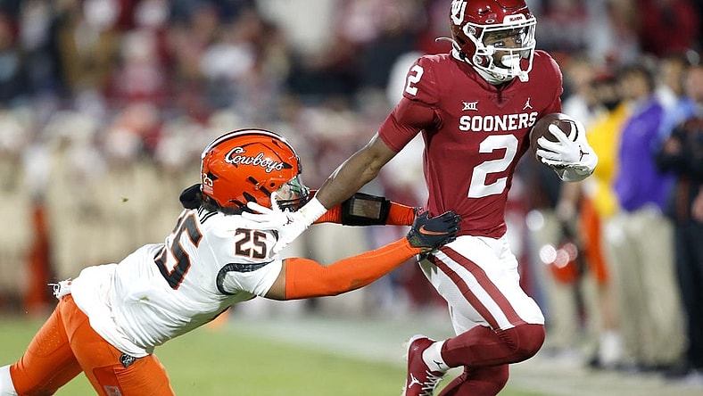 Nov 19, 2022; Norman, Oklahoma, USA;  Oklahoma Sooners running back Jovantae Barnes (2) runs the ball against Oklahoma State Cowboys safety Jason Taylor II (25)  in the second quarter at Gaylord Family-Oklahoma Memorial Stadium. Mandatory Credit: Sarah Phipps-USA TODAY Sports