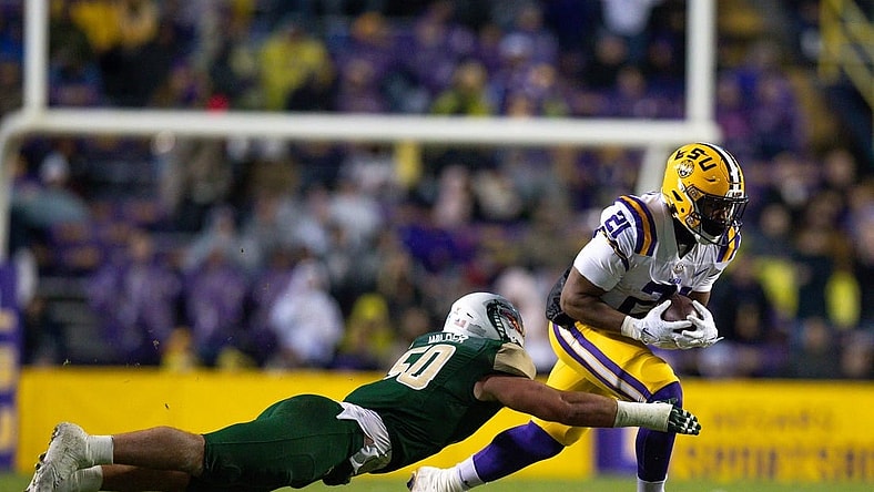 Nov 19, 2022; Baton Rouge, Louisiana, USA;  LSU Tigers running back Noah Cain (21) rushes against UAB Blazers linebacker Noah Wilder (50) during the first half at Tiger Stadium. Mandatory Credit: Stephen Lew-USA TODAY Sports
