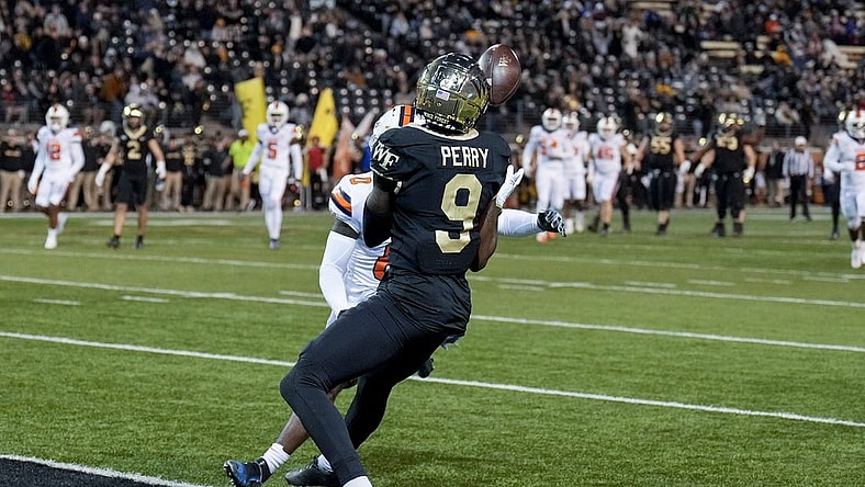 Nov 19, 2022; Winston-Salem, North Carolina, USA; Wake Forest Demon Deacons wide receiver A.T. Perry (9) makes a catch against Syracuse Orange defensive back Darian Chestnut (0) to score during the first half at Truist Field. Mandatory Credit: Jim Dedmon-USA TODAY Sports