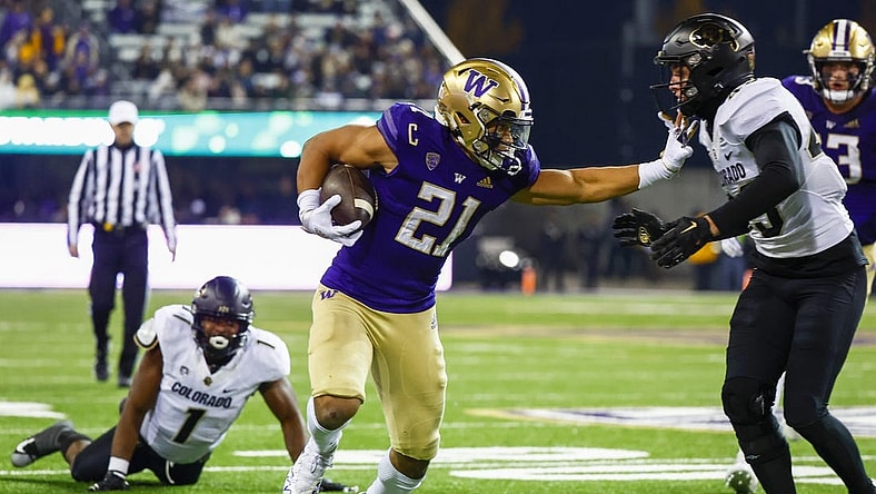 Nov 19, 2022; Seattle, Washington, USA; Washington Huskies running back Wayne Taulapapa (21) stiff arms against Colorado Buffaloes safety Trevor Woods (43) during the second quarter at Alaska Airlines Field at Husky Stadium. Mandatory Credit: Joe Nicholson-USA TODAY Sports