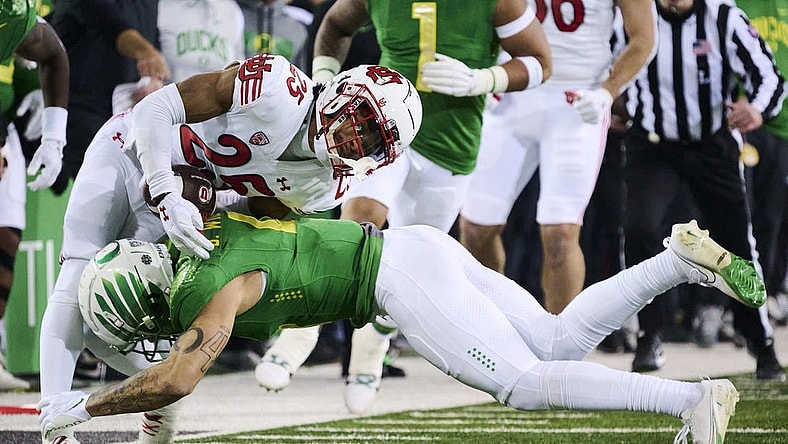 Nov 19, 2022; Eugene, Oregon, USA; Oregon Ducks defensive back Bennett Williams (4) tackles Utah Utes wide receiver Jaylen Dixon (25) during the first half at Autzen Stadium. Mandatory Credit: Troy Wayrynen-USA TODAY Sports