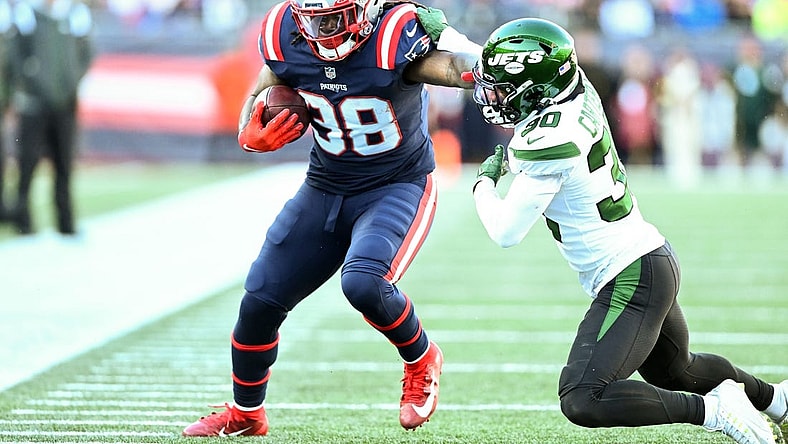 Nov 20, 2022; Foxborough, Massachusetts, USA; New England Patriots running back Rhamondre Stevenson (38) runs with the ball against New York Jets cornerback Michael Carter II (30) during the first half at Gillette Stadium. Mandatory Credit: Brian Fluharty-USA TODAY Sports