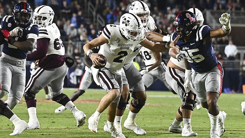 Nov 24, 2022; Oxford, Mississippi, USA; Mississippi State Bulldogs quarterback Will Rogers (2) moves in the pocket while defended by Ole Miss Rebels defensive end Tavius Robinson (95) during the first quarter at Vaught-Hemingway Stadium. Mandatory Credit: Matt Bush-USA TODAY Sports