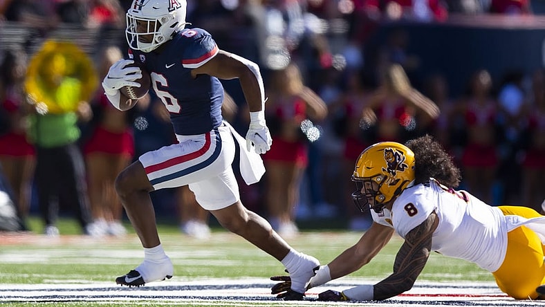 Nov 25, 2022; Tucson, Arizona, USA; Arizona Wildcats running back Michael Wiley (6) runs for a touchdown against diving Arizona State Sun Devils linebacker Merlin Robertson (8) in the first half of the Territorial Cup at Arizona Stadium. Mandatory Credit: Mark J. Rebilas-USA TODAY Sports