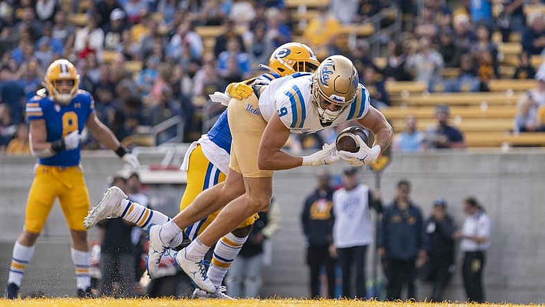 November 25, 2022; Berkeley, California, USA; UCLA Bruins wide receiver Jake Bobo (9) scores a touchdown against California Golden Bears safety Craig Woodson (2) during the first quarter at California Memorial Stadium. Mandatory Credit: Kyle Terada-USA TODAY Sports