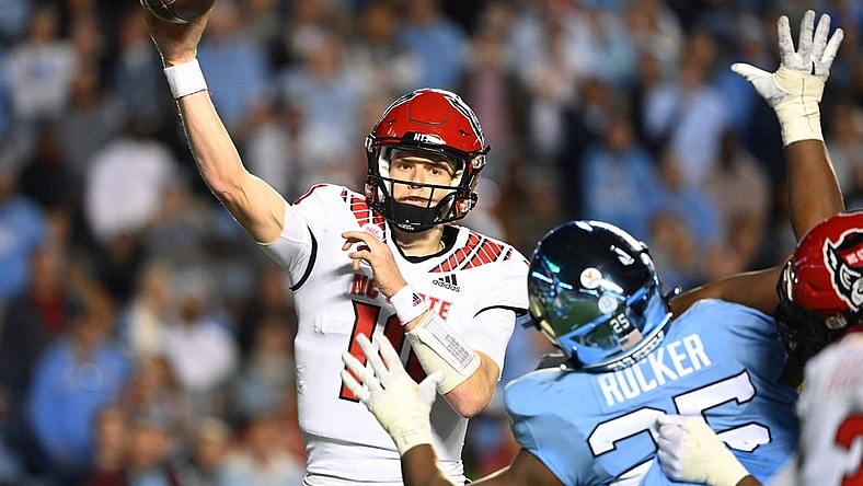 Nov 25, 2022; Chapel Hill, North Carolina, USA; North Carolina State Wolfpack quarterback Ben Finley (10) passes the ball as North Carolina Tar Heels defensive lineman Kaimon Rucker (25) defends in the fourth quarter at Kenan Memorial Stadium. Mandatory Credit: Bob Donnan-USA TODAY Sports