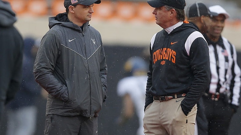 Nov 26, 2022; Stillwater, Oklahoma, USA; West Virginia Mountaineers head coach Neal Brown, left, and Oklahoma State Cowboys head coach Mike Gundy talk before a college football game between Oklahoma State and West Virginia at Boone Pickens Stadium in Stillwater, Okla., Saturday, Nov. 26, 2022.   Mandatory Credit: Bryan Terry-USA TODAY Sports