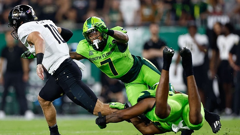 Nov 26, 2022; Tampa, Florida, USA; UCF Knights quarterback John Rhys Plume (10) scrambles with the ball as South Florida Bulls safety Will Jones II (7) defends during the first quarter at Raymond James Stadium. Mandatory Credit: Douglas DeFelice-USA TODAY Sports