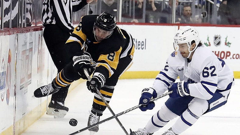 Nov 26, 2022; Pittsburgh, Pennsylvania, USA;  Pittsburgh Penguins defenseman Brian Dumoulin (8) and Toronto Maple Leafs center Denis Malgin (62) battle for the puck during the second period at PPG Paints Arena. Toronto won 4-1. Mandatory Credit: Charles LeClaire-USA TODAY Sports