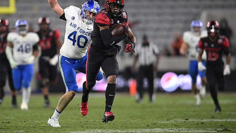 Nov 26, 2022; San Diego, California, USA; San Diego State Aztecs wide receiver Brionne Penny (11) runs with the ball as Air Force Falcons linebacker Alec Mock (40) prepares to punch the ball during the second half at Snapdragon Stadium. Mandatory Credit: Orlando Ramirez-USA TODAY Sports