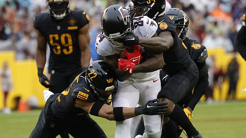 Nov 27, 2022; Landover, Maryland, USA; Atlanta Falcons running back Cordarrelle Patterson (84) has his face mask grabbed by Washington Commanders cornerback Christian Holmes (34) while running with the ball during the first quarter at FedExField. Mandatory Credit: Geoff Burke-USA TODAY Sports
