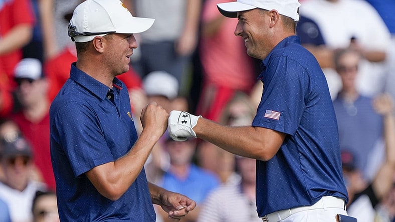 Sep 24, 2022; Charlotte, North Carolina, USA; Team USA golfer Justin Thomas (left) and golfer Jordan Spieth (right) celebrate after winning the match on the 15th green during the four-ball match play of the Presidents Cup golf tournament at Quail Hollow Club. Mandatory Credit: Jim Dedmon-USA TODAY Sports