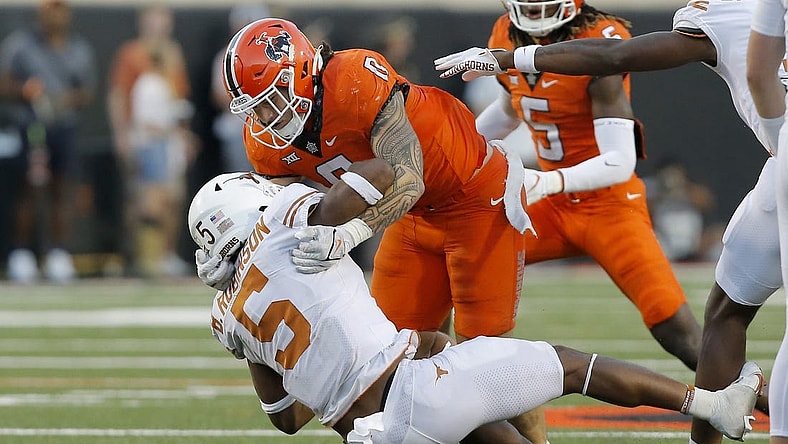 Oct 22, 2022; Stillwater, Oklahoma, USA;  Oklahoma State Cowboys linebacker Mason Cobb (0) brings down Texas Longhorns running back Bijan Robinson (5) during a game at Boone Pickens Stadium. Mandatory Credit: Bryan Terry/The Oklahoman via USA TODAY NETWORK