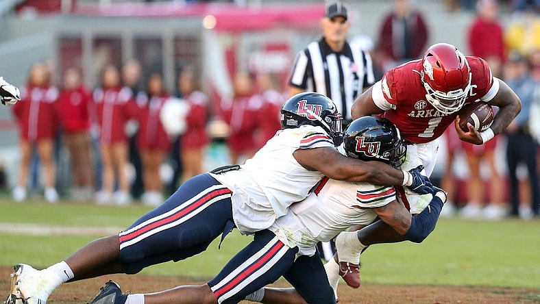 Nov 5, 2022; Fayetteville, Arkansas, USA; Liberty Flames defensive tackle Dre Butler (5) and defensive end Durrell Johnson (11) tackle Arkansas Razorbacks quarterback KJ Jefferson (1) in the second half at Donald W. Reynolds Razorback Stadium. Liberty won 21-19. Mandatory Credit: Nelson Chenault-USA TODAY Sports
