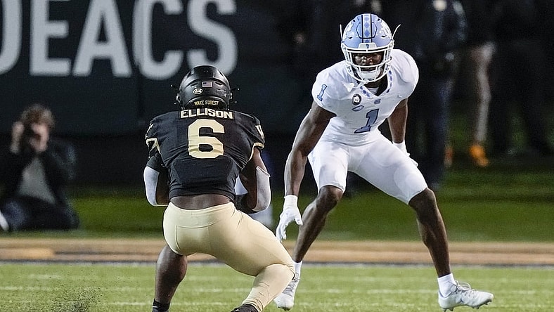 Nov 12, 2022; Winston-Salem, North Carolina, USA;  Wake Forest Demon Deacons running back Justice Ellison (6) tries to evade North Carolina Tar Heels defensive back Tony Grimes (1) during the second half at Truist Field. Mandatory Credit: Jim Dedmon-USA TODAY Sports